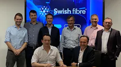 Rob Skinner, Octopus, with Brice Yharrassarry, CEO of Swish Fibre, signing their new agreement supported by their respective teams.