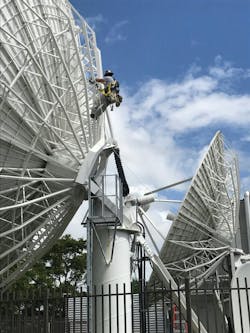 A USSI Global field engineer performing maintenance on a satellite dish at a customer facility in Miami, Florida. A USSI Global field engineer performing maintenance on a satellite dish at a customer facility in Miami, Florida.