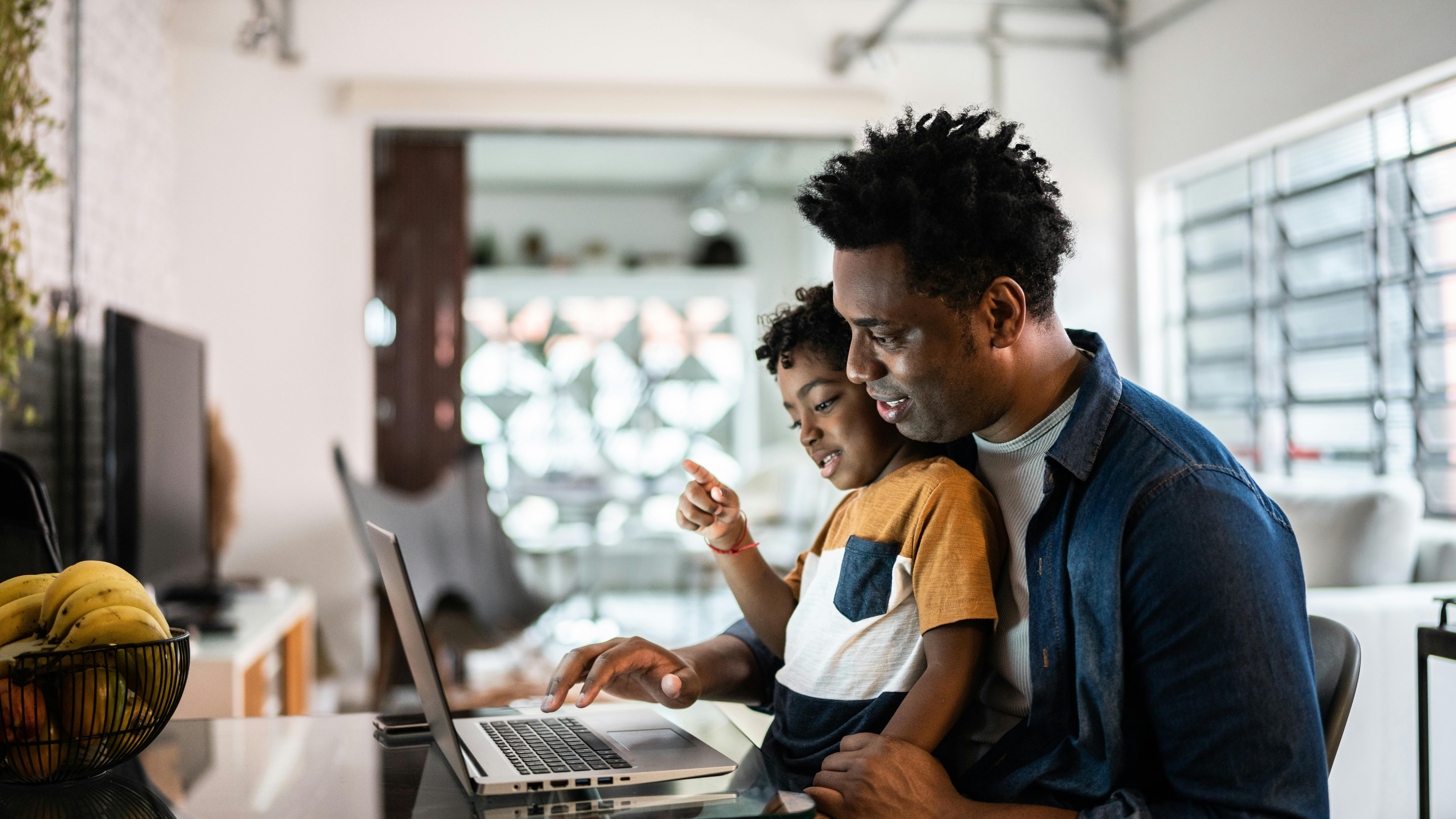 A father and son using a laptop at home