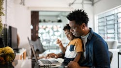 A father and son using a laptop at home A father and son using a laptop at home