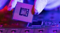 A gloved hand holding a semiconductor. A gloved hand holding a semiconductor.