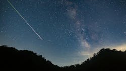 A meteor shoots across the night sky sky leaving a trail of light across the milky way A meteor shoots across the night sky sky leaving a trail of light across the milky way
